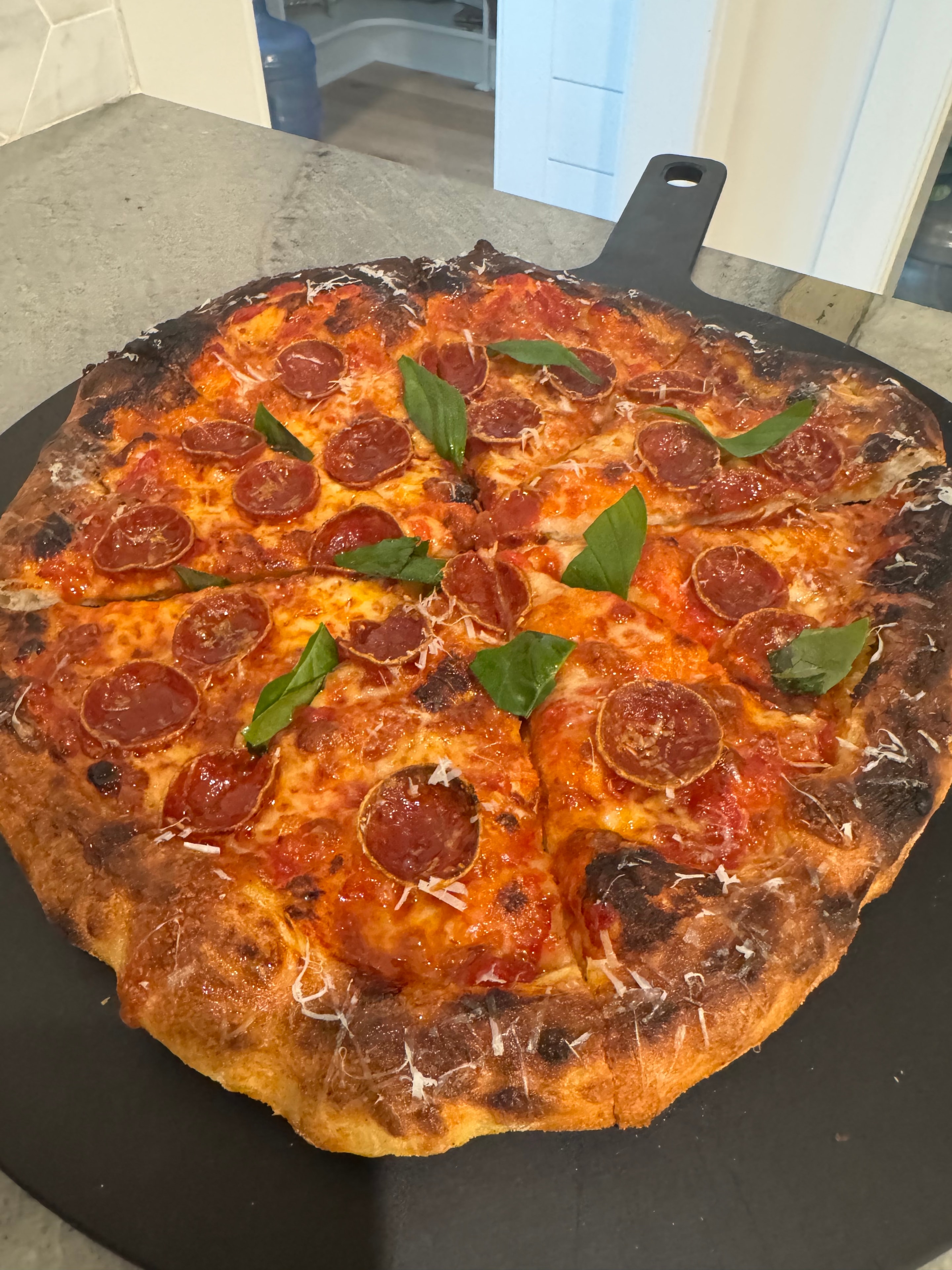 Pepperoni pizza cooling on wire rack
