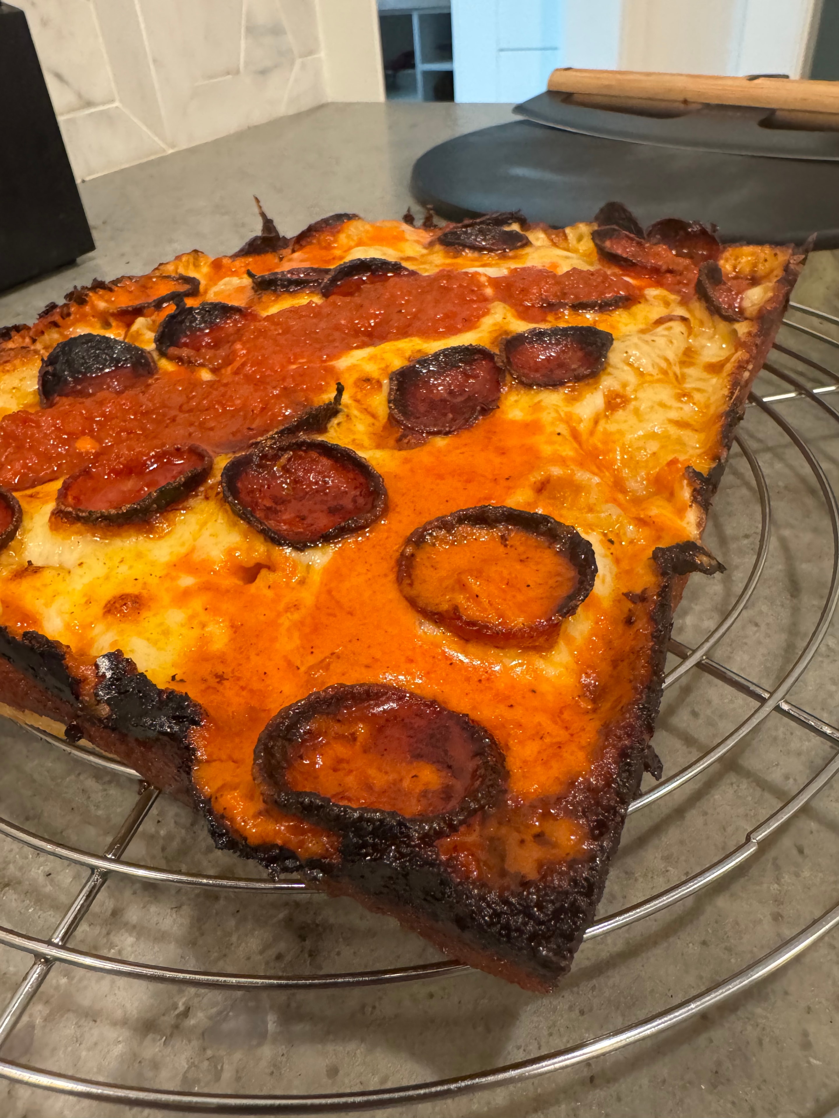 Pepperoni pizza slice on cooling rack